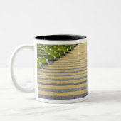 Stadiumtrap tussen rijen groene stoelen tweekleurige koffiemok (Links)