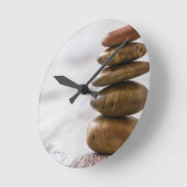 stapel donkergekleurde stenen op witte achtergrond ronde klok (Hoek)