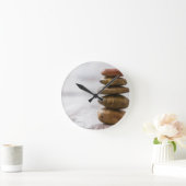 stapel donkergekleurde stenen op witte achtergrond ronde klok (Huis)