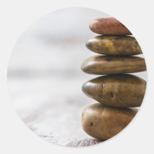 stapel donkergekleurde stenen op witte achtergrond ronde sticker
