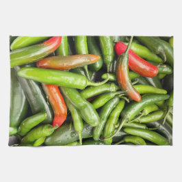 Stapel van groene pittige paprika's theedoek