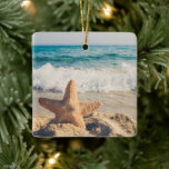 Starfish op een foto van Sandy Beach Keramisch Ornament<br><div class="desc">Een ornament met een schilderachtig foto. Een grote zeester die rechtop op een zandstrand staat. Een mooi blauw zee met golven wit surf op de achtergrond.</div>