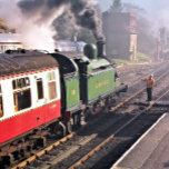 STEAM TRAINS TEGELTJE<br><div class="desc">Een prachtig gerestaureerde stoomtrein en rijtuigen van een voorbijgaand tijdperk die het treinstation verlaten en de machinist de sleutel overhandigt voordat hij toestemming krijgt om door de trein te rijden. Engeland.</div>