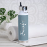 Stijlvolle Stusty Blue White Script Womens Waterfles<br><div class="desc">Blijf gehydrateerd tijdens je gymnastiekbaan met deze stijlvolle Dusty Blue White Script Women's Water Bottle. Het is trendy modern ontworpen met trendy blauwe achtergrond rond de fles. De naam is in wit handmanuscript dat verticaal op centrumvoorzijde laat lettertypen. Perfect cadeauidee voor haar! KLIK PERSONALIZE DE OPTIE VAN DE SJABLOON EN...</div>