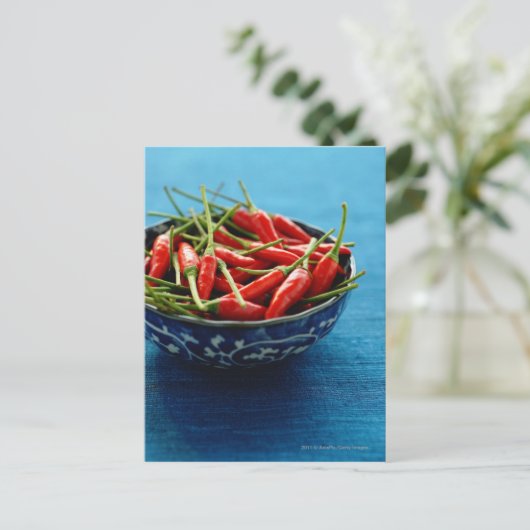 Stilleven van chilies in kom op blauwe mat briefkaart (Staand voorkant)