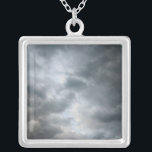 Storm wolken breken zilver vergulden ketting<br><div class="desc">Donkere stormachtige wolken breken uit elkaar in de voorgrond van deze kleurenfoto. De wolkenlagen worden lichtere schaduwen van grijs dieper in het afbeelding. De wenken van de lichtblauwe hemel zijn zichtbaar voorbij de wolken van het storm terwijl het weer begint op te ruimen. Digitale kleurenfoto. Copyright © 2010 Claire E....</div>