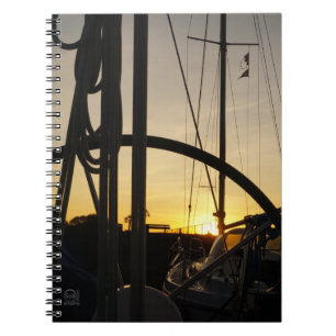 Stuurwiel van zeiljacht met ondergaande zon. notitieboek