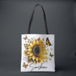 Sunshine Be the Sunshine | Tote Bag<br><div class="desc">This tote bag features a clean, modern design with a soft, uplifting aesthetic. The bag itself is white with sturdy black shoulder straps, creating a nice contrast that makes the artwork stand out. The front showcases a large, beautifully detailed sunflower in rich golden and amber tones, with layered petals and...</div>