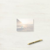 Surfbordlagen op het strand als de zon verschijnt post-it® notes (Op bureau)