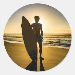 Surfer-silhouet tijdens zonsopgang ronde sticker