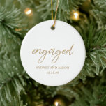Sydney Gold First Christmas verloofd met moderne Keramisch Ornament<br><div class="desc">Modern kerstornament met een hedendaags typografisch ontwerp met "betrokken" elegante scripttypografie, samen met uw namen en verloving datum in een eenvoudige en minimale lay-out. Op de achterkant staat je favoriete foto. Het kleurthema is goud en wit en kan worden gewijzigd in het ontwerpbewerkingshulpmiddel. Dit minimalistische stijl ornament is geweldig voor...</div>