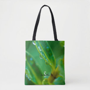 Tas met regendruppels op groene bladeren