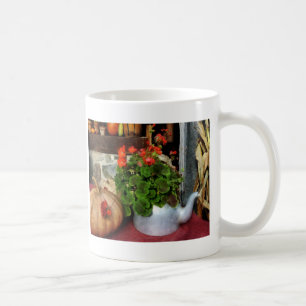 Teapot gevuld met geraniums koffiemok