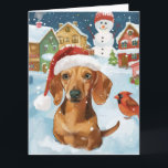 Teckel Winter Wonderland Christmas Joy Kaart<br><div class="desc">Dit feestelijke ontwerp vangt de vrolijke sfeer van het vakantieseizoen, met een schattige pup die een kerstmuts draagt. De hond is genesteld in een winterwonderland, compleet met een sneeuwpop, een versierde kerstboom en prachtig ingepakte cadeaus. Sneeuwvlokken herfsten zachtjes en voegen een magische toets toe aan het tafereel, terwijl de levendige...</div>