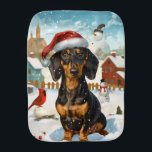 Teckel Winter Wonderland Christmas Joy Monddoekje<br><div class="desc">Dit feestelijke ontwerp vangt de vrolijke sfeer van het vakantieseizoen, met een schattige pup die een kerstmuts draagt. De hond is genesteld in een winterwonderland, compleet met een sneeuwpop, een versierde kerstboom en prachtig ingepakte cadeaus. Sneeuwvlokken herfsten zachtjes en voegen een magische toets toe aan het tafereel, terwijl de levendige...</div>