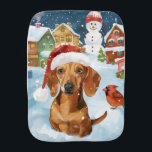 Teckel Winter Wonderland Christmas Joy Monddoekje<br><div class="desc">Dit feestelijke ontwerp vangt de vrolijke sfeer van het vakantieseizoen, met een schattige pup die een kerstmuts draagt. De hond is genesteld in een winterwonderland, compleet met een sneeuwpop, een versierde kerstboom en prachtig ingepakte cadeaus. Sneeuwvlokken herfsten zachtjes en voegen een magische toets toe aan het tafereel, terwijl de levendige...</div>