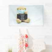 Teddy beer draag gezichtsmasker met handhanden spandoek (Insitu)