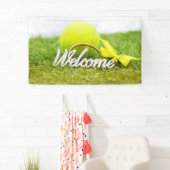 Tennisballen en rackets verwelkomen woord op groen spandoek (Insitu)