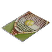 Tennisracket met bal op de baan notitieboek (Linkerzijde)