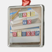Terug naar schoolbouwstenen op gestapelde boeken metalen ornament (Links)