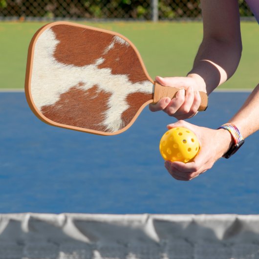textuur van bruin en wit koeienhuid pickleball paddle (Insitu)