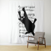 The cat hangs on musical notes wandkleed (In situ)