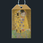 The Lovers Kissingembrace by Gustav Klimt Cadeaulabel<br><div class="desc">Het zonlicht schittert door de wervelende gouden omhelzing die de geliefden omringt in Gustav Klimts meesterwerk, The Kiss. De scène is een paradox van intimiteit en isolatie. Het paar staat op een afgrond, een veld van kleurrijke bloemen aan hun voeten, maar ze zijn zich niet bewust van de wereld om...</div>