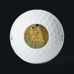 The Lovers Kissingembrace by Gustav Klimt Golfballen<br><div class="desc">Het zonlicht schittert door de wervelende gouden omhelzing die de geliefden omringt in Gustav Klimts meesterwerk, The Kiss. De scène is een paradox van intimiteit en isolatie. Het paar staat op een afgrond, een veld van kleurrijke bloemen aan hun voeten, maar ze zijn zich niet bewust van de wereld om...</div>