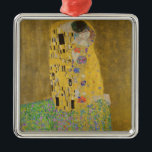 The Lovers Kissingembrace by Gustav Klimt Metalen Ornament<br><div class="desc">Het zonlicht schittert door de wervelende gouden omhelzing die de geliefden omringt in Gustav Klimts meesterwerk, The Kiss. De scène is een paradox van intimiteit en isolatie. Het paar staat op een afgrond, een veld van kleurrijke bloemen aan hun voeten, maar ze zijn zich niet bewust van de wereld om...</div>