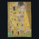 The Lovers Kissingembrace by Gustav Klimt Theedoek<br><div class="desc">Het zonlicht schittert door de wervelende gouden omhelzing die de geliefden omringt in Gustav Klimts meesterwerk, The Kiss. De scène is een paradox van intimiteit en isolatie. Het paar staat op een afgrond, een veld van kleurrijke bloemen aan hun voeten, maar ze zijn zich niet bewust van de wereld om...</div>