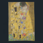 The Lovers Kissingembrace by Gustav Klimt Theedoek<br><div class="desc">Het zonlicht schittert door de wervelende gouden omhelzing die de geliefden omringt in Gustav Klimts meesterwerk, The Kiss. De scène is een paradox van intimiteit en isolatie. Het paar staat op een afgrond, een veld van kleurrijke bloemen aan hun voeten, maar ze zijn zich niet bewust van de wereld om...</div>