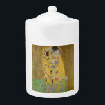 The Lovers Kissingembrace by Gustav Klimt Theepot<br><div class="desc">Het zonlicht schittert door de wervelende gouden omhelzing die de geliefden omringt in Gustav Klimts meesterwerk, The Kiss. De scène is een paradox van intimiteit en isolatie. Het paar staat op een afgrond, een veld van kleurrijke bloemen aan hun voeten, maar ze zijn zich niet bewust van de wereld om...</div>