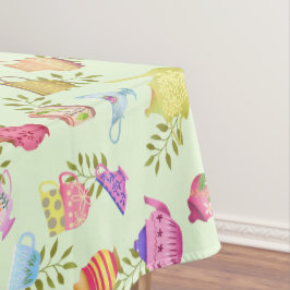 Theepotten en kopjes groen tafelkleed