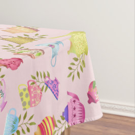 Theepotten en kopjes roze tafelkleed