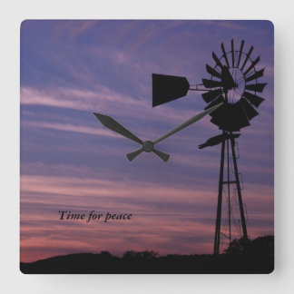 Tijd voor vredesmuur klok met windmolen op zonsond