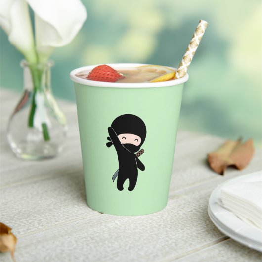 Tiny Happy Ninja over Green Papieren Bekers (Insitu)