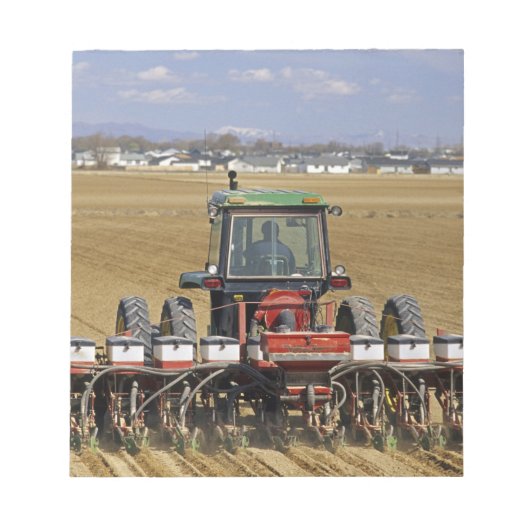 Tractor die een maiszaaimachine trekt. notitieblok (Voorkant)