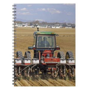 Tractor die een maiszaaimachine trekt. notitieboek