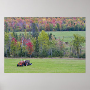 Tractor met hooibaal in groen veld met poster
