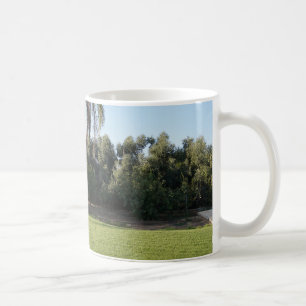 Tranquil Escape: weelderige gazon en torenhoge bom Koffiemok