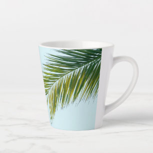 Tropisch groene palmblad op lichtblauw latte mok