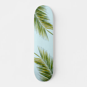 Tropisch groene palmblad op lichtblauw persoonlijk skateboard