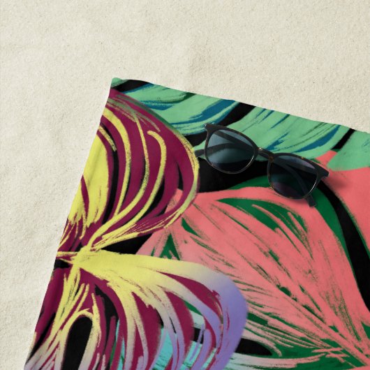 Tropisch kleurrijk monsterblad op zwart strandlaken (In situ)