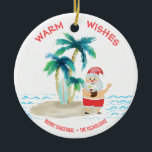 Tropisch Surfende kerstkerst met kerstmis Keramisch Ornament<br><div class="desc">De kerstman neemt een broodnodige vakantie en leeft het goede leven, surft en ontspant op een tropisch eilandstrand. Hij heeft zijn tenen in het zand, een drink in zijn hand, palmbomen en een warme oceaanbries. De groet van de "Warm van de Vergroting"is in een koraalkleur over de bovenkant. Pas uw...</div>