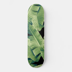 Tropische bananenbladeren verlaten het nachtelijke persoonlijk skateboard