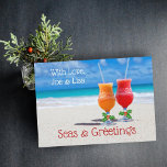 Tropische kerst Drinken in de Zand Kaarten<br><div class="desc">Eenvoudige tropische kerstkaartlezer. Twee koude cocktails met rietjes zitten op warm strand zand met blauw water op de achtergrond. Elk glas is voorzien van een groene holly en bessen op de stengel van het glas. Pas de kaart aan met een handtekening bovenaan en begroet onderaan. Houd de "zeeen en groeten"...</div>