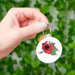 Tropische rode hibiscus bloem met groene bladeren sleutelhanger