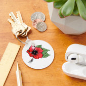 Tropische rode hibiscus bloem met groene bladeren sleutelhanger