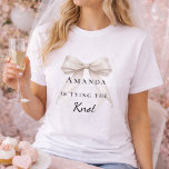 Trouwboog ivoor lint parels vrijgezellenfeest t-shirt<br><div class="desc">Til je bruiloftsfeesten naar een hoger niveau met deze verfijnde coquette-themapartycollectie. Elk onderdeel toont een hoogwaardige ivoren boog gecombineerd met delicate parelaccenten en tijdloze typografie. Deze set is perfect voor de moderne bruid die een samenhangende look wil voor haar vrijgezellenreis en bruidsfeest.</div>