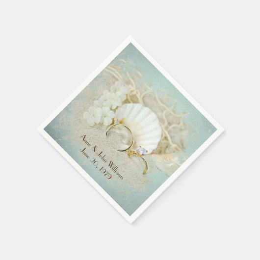 trouwringen en zeeschelpen in zand servet (Hoek)